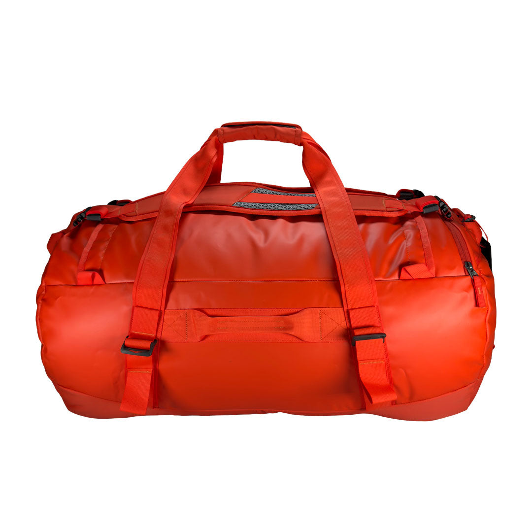 Back view of 85 litre Tatonka barrel bag with adjustable, top carry handles, grab handles on all sides, and padded, removable and adjustable backpack shoulder straps. Main body has compression straps and a padded bottom - Red