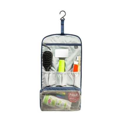 Front view of Tatonka Travelcare foldable wash bag in use and opened out to reveal two large, zipped compartments, four flat insert pockets, a detachable unbreakable mirror and a dedicated pocket to store a flannel or quick dry towel. Wash bag is shown hanging from the stowable rotating hanging hook - Navy